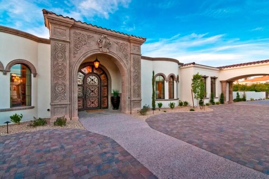 Carved stone arch and wrought iron entry at Mockingbird Estate by Calvis Wyant