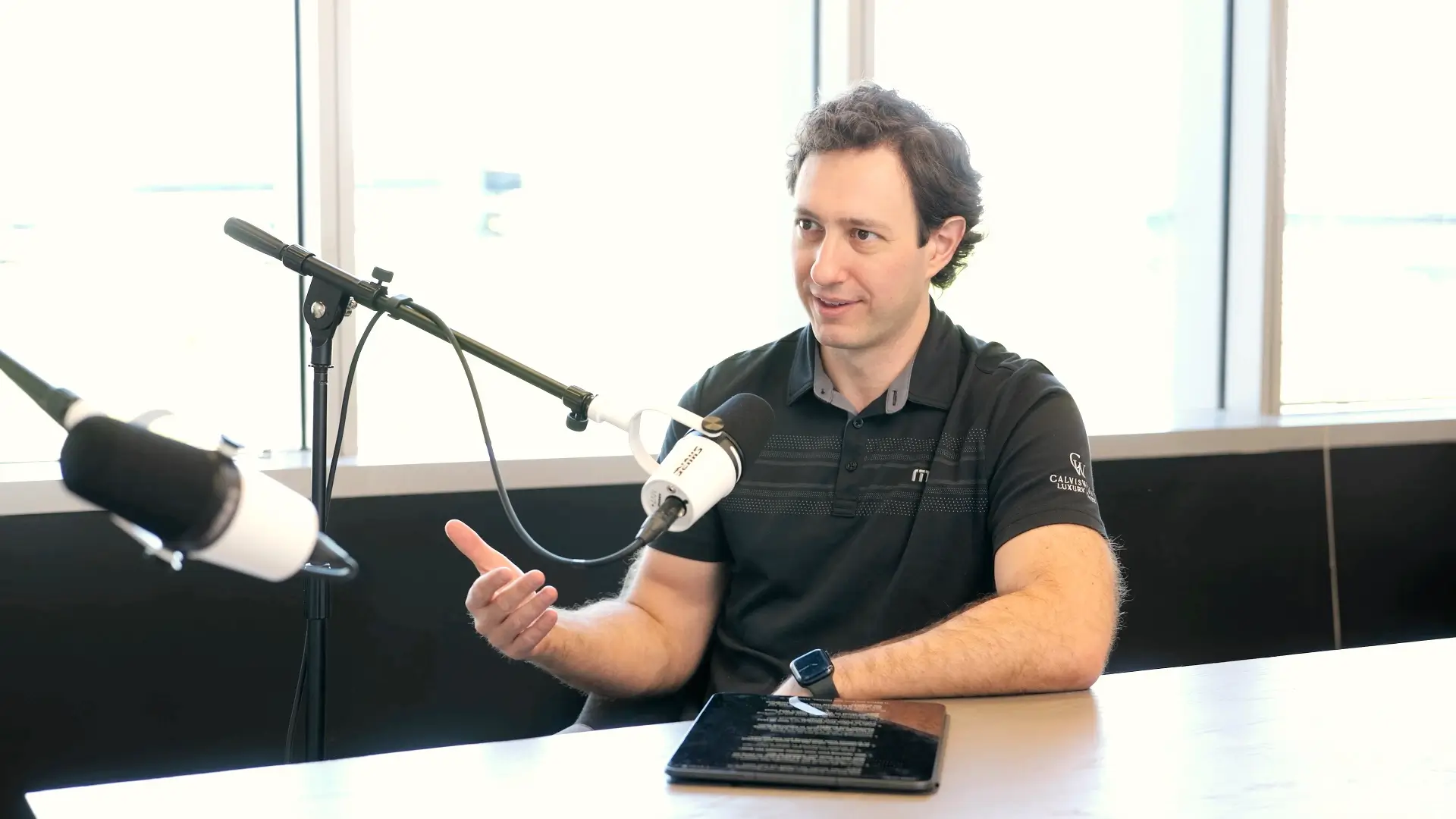 Tony Calvis, Jr. speaking into a microphone during The Calvis Wyant Podcast